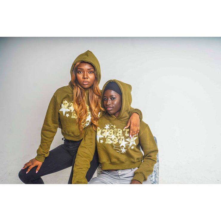 Two girls wearing olive green hoodies with a design that shows "R3BIRTH EST &