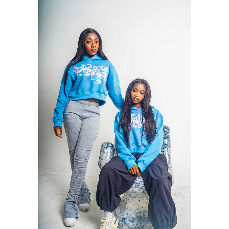 Two girls wearing blue hoodies with a design that shows "R3BIRTH EST &
