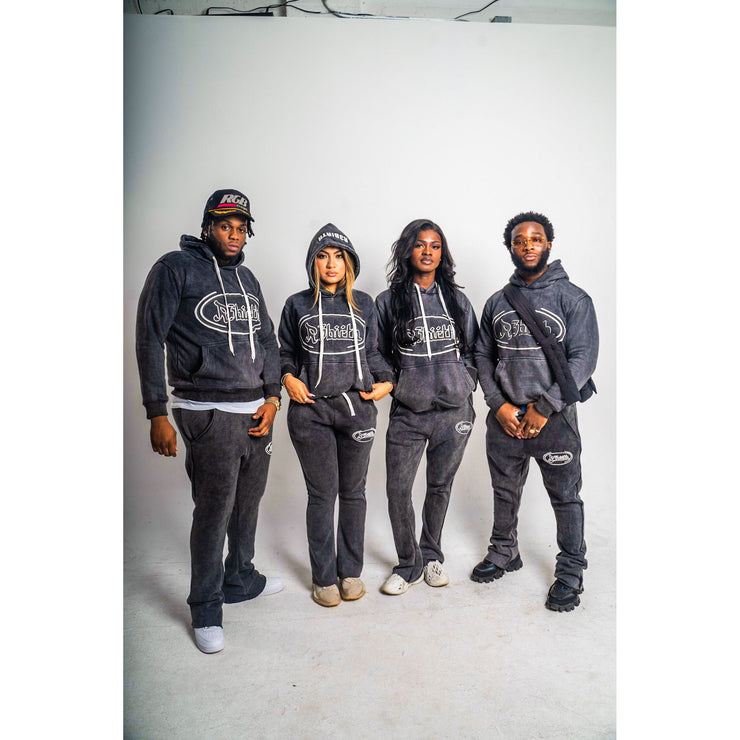 Four people wearing black acid washed joggers with a R3Birth logo on left