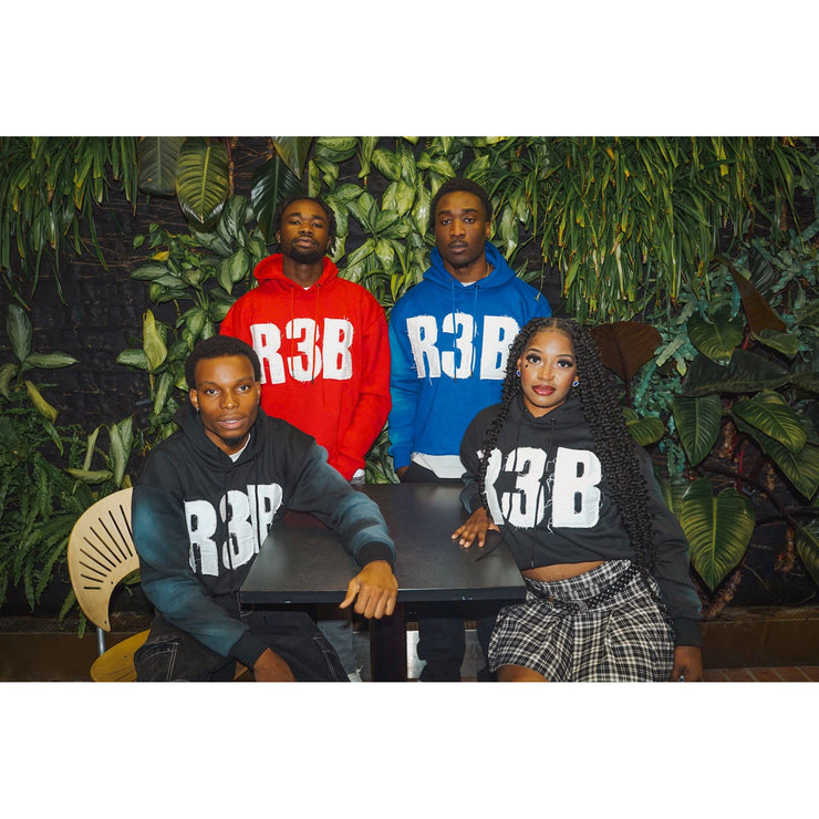 Four people wearing crop hoodies with a design that shows "R3B"