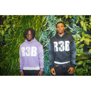 Two men wearing a lavender and black crop hoodie with a design that shows 'R3B'